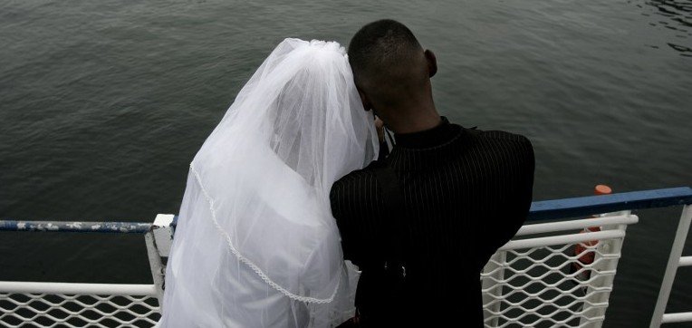 A South African couple look at the sea on February 14, 2008 in the Victoria and Albert waterfront harbour as they get ready to reach Robben Island to get married on Valentine's day. As a tradition since 2000 couples willing to get married are given the possibility to do it on Valentine's day in the chapel of the former Apartheid prison and world heritage site of Robben Island. AFP PHOTO / GIANLUIGI GUERCIA / AFP PHOTO / GIANLUIGI GUERCIA